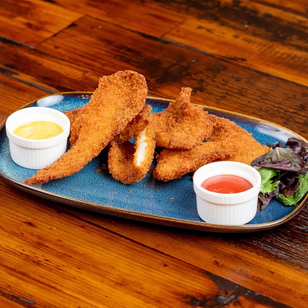 Crispy fried chicken tenders with two dipping sauces and a small salad on a blue plate.